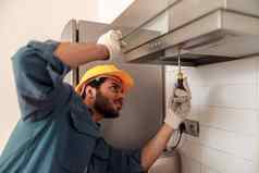 杂工统一的修复厨房器替换过滤器炊具罩维护概念