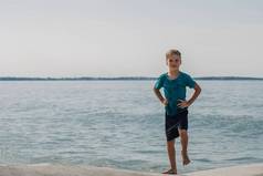 男孩金发碧眼的微笑有趣的表达式明亮的太阳迷人的自然体育运动海海滩湿夏天