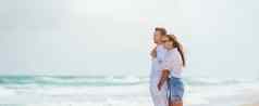 年轻的夫妇爱海滩夏天假期快乐男人。女人海