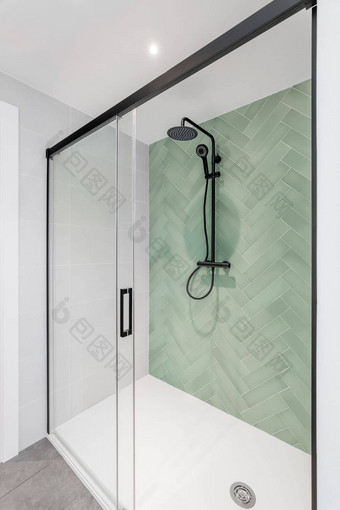 现代浴室光绿色白色瓷砖雨头<strong>手举行</strong>淋浴玻璃通过