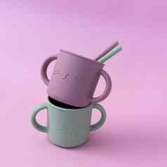 现代柔和的颜色硅胶吸管杯吸管粉红色的背景婴儿餐具喂养服务概念新浪微博