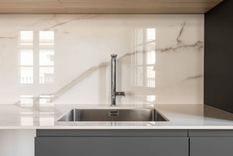 现代小广场水槽厨房时尚内置的不锈钢钢水槽室内厨房白色灰色的颜色大理石瓷砖墙白色工作台面灰色的厨房内阁