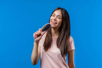 女人唱歌跳舞头发刷麦克风蓝色的背景少年女孩有趣的听音乐卡拉ok梦想名人