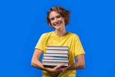 聪明的学生女人持有堆栈大学书大学图书馆蓝色的背景快乐女孩微笑快乐研究生