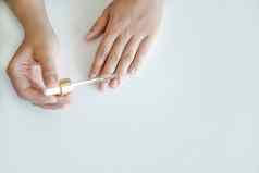 指甲手皮肤护理女人持有吸管石油应用指甲治疗加强指甲手特写镜头复制空间