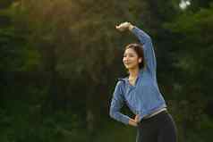 肖像亚洲女人温暖的体育培训在户外健身体育运动健康的生活方式概念