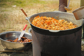 烹饪传统的东方皮拉夫大大锅阳光明媚的一天户外真正的乌兹别克皮拉夫草原