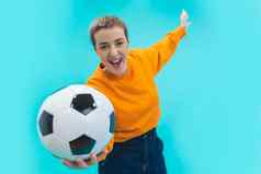 尖叫年轻的女人女孩足球足球风扇橙色毛衣孤立的蓝色的背景