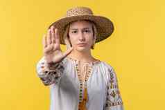 不感兴趣乌克兰女人不赞成的手标志手势否认拒绝不同意肖像年轻的夫人黄色的背景超时概念