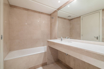 大白色清洁浴缸洗澡每天洗澡墙全身的镜子大理石桌面的脸盆现代浴室时尚的瓷砖装饰软米色