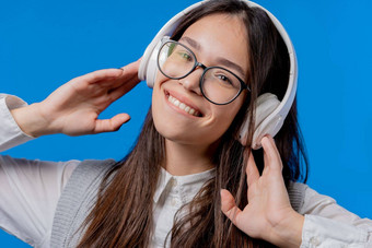 快乐学生少年听音乐享受跳舞耳机蓝色的工作室背景广播无线现代声音技术在线球员
