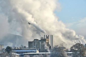 环境问题污染环境空气城市吸烟<strong>工业</strong>区工厂<strong>烟囱</strong>视图大植物吸烟管道烟纸行业运行一天一年照片12月空气污染城市烟<strong>烟囱</strong>蓝色的天空背景