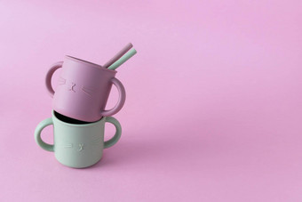 现代柔和的颜色硅胶吸管杯吸管粉红色的背景婴儿餐具喂养服务概念空间文本