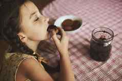 可爱的有趣的蹒跚学步的女孩吃甜蜜的好早餐快乐孩子吃面包卷草莓小时健康食物孩子们孩子们自制果冻