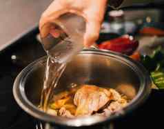 女人手添加水烹饪能准备鸡汤食物老板烹饪概念