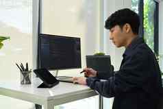 亚洲男人。开发人员工作编码数据电脑屏幕发展中编程编码技术概念