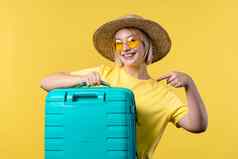 少年旅行蓝色的行李袋飞机手行李年轻的漂亮的女人随身携带的手提箱黄色的背景夏天旅行假期概念
