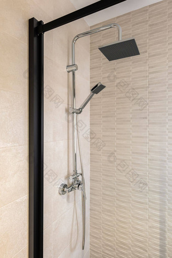 现代淋浴区黑色的雨头手举行淋浴米色瓷砖浴室