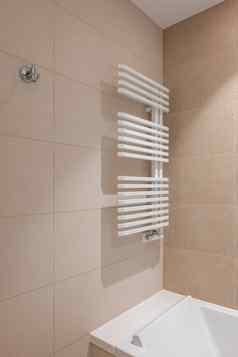 角落里浴室中心白色加热散热器墙干燥毛巾墙房间排米色瓷砖颜色纯白色丙烯酸浴缸