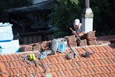 建设工人瓷砖屋面修复阳光明媚的一天