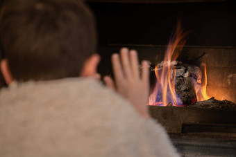 后视图年轻的男孩包装毯子气候变暖手前面柴火冬天