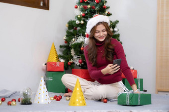 亚洲年轻的女人视频闲谈，聊天智能手机显示现在盒子朋友圣诞节树