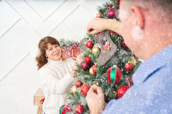 微笑快乐中间年龄夫妇装修圣诞节树首页快乐夫妇首页圣诞节概念