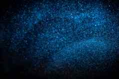 真正的蓝色的灰尘粒子黑色的背景闪闪发光的闪闪发光的散景覆盖复制空间