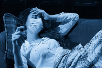 年轻的女人沙发覆盖毯子冻结吹运行鼻子发热抓住了生病的女孩流感症状流感病毒概念
