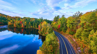 空中路蓝色的湖包围秋天森林