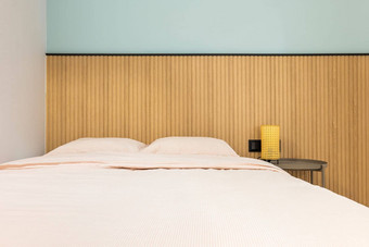 前面视图双床上枕头使大温暖的羽绒被床单愉快的米色颜色现代设计墙木镶板