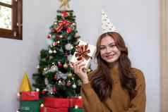 快乐圣诞节快乐假期年轻的女人美丽的脸黄色的衬衫显示快乐礼物盒子房子圣诞节树装饰圣诞节树肖像圣诞节