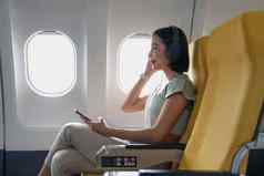 年轻的女听最喜欢的歌曲飞行类小屋移动播放列表附件女人娱乐飞机董事会享受音乐耳机智能手机