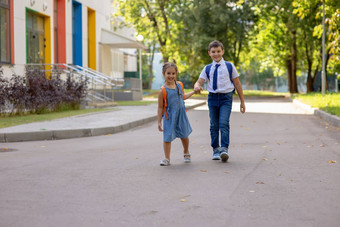 快乐的小学生女孩男孩白色衬衫背包学校