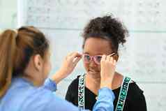 可爱的女孩测试眼镜验光师光学商店视力愿景概念