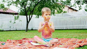 孩子四岁的男孩玩绘画手指油漆装修花园坐着毯子草草坪上夏天有趣的