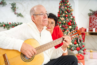父亲玩吉他圣诞节快乐男人。玩吉他圣诞节歌曲