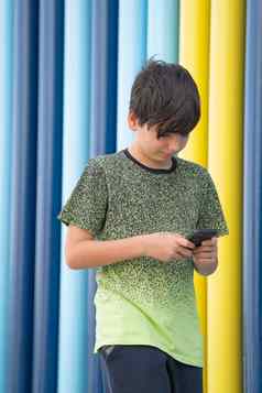 肖像年轻的男孩智能手机走彩色背景沉浸技术概念