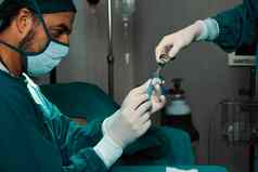 外科医生填满注射器瓶外科手术过程无菌操作房间