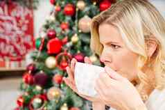 女孩白色毛衣持有杯温暖的咖啡茶背景圣诞节树