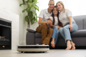年轻的家庭休息沙发上机器人真空更清洁的工作首页家庭机器人概念