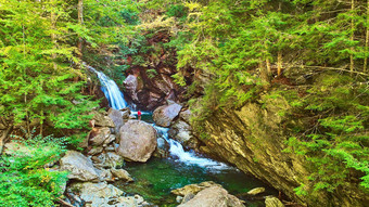 空中河岩石喉咙郁郁葱葱的绿色森林瀑布孤独的徒步旅行者观察瀑布博尔德