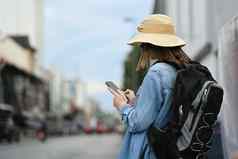 回来视图年轻的女人旅行者智能手机平台应用程序帮助旅游旅行地图全球定位系统(gps)