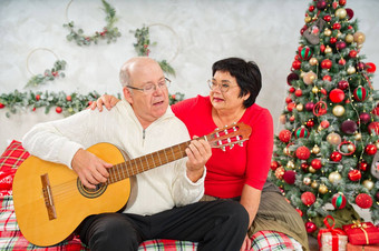 父亲玩吉他圣诞节快乐男人。玩吉他圣诞节歌曲