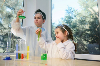 聪明的孩子们十几岁的男孩学龄前儿童女孩进行化学实验学校科学实验室