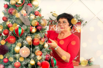 女人装修美丽的圣诞节树首页特写镜头圣诞节假期人概念