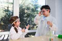 可爱的高加索人多样化的孩子们享受化学教训学校实验室