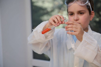 特写镜头小学生的手测试管化学物质试剂化学类学校科学实验室