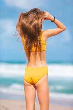 可爱的苗条的女孩黄色的泳衣完美的数字海滩