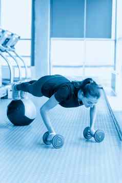 女人地板上锻炼健身房健身女孩哑铃医学球板材